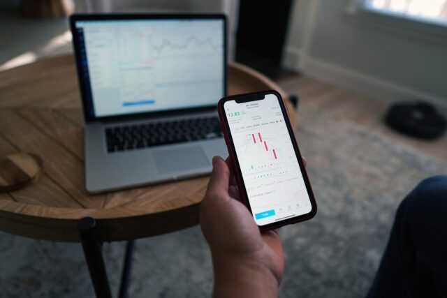 Photo by TheInvestorPost smartphone, hand, stocks