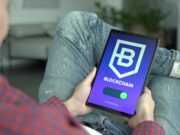 Блокчейн и безопасность — защита личной информации Adult holding a digital tablet displaying a blockchain application interface.