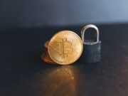 Успехи компаний с блокчейн-технологиями a bit coin sitting on top of a padlock