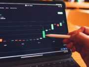 Блокчейн — Путь к устойчивому бизнесу a person is holding a pencil in front of a laptop