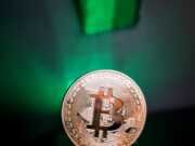 Выбор платформы для обмена криптовалют a hand holding a bit coin in front of a green light