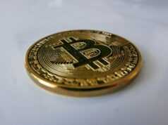 Как работают смарт‑контракты — от кода до исполнения a gold bit coin sitting on top of a white table